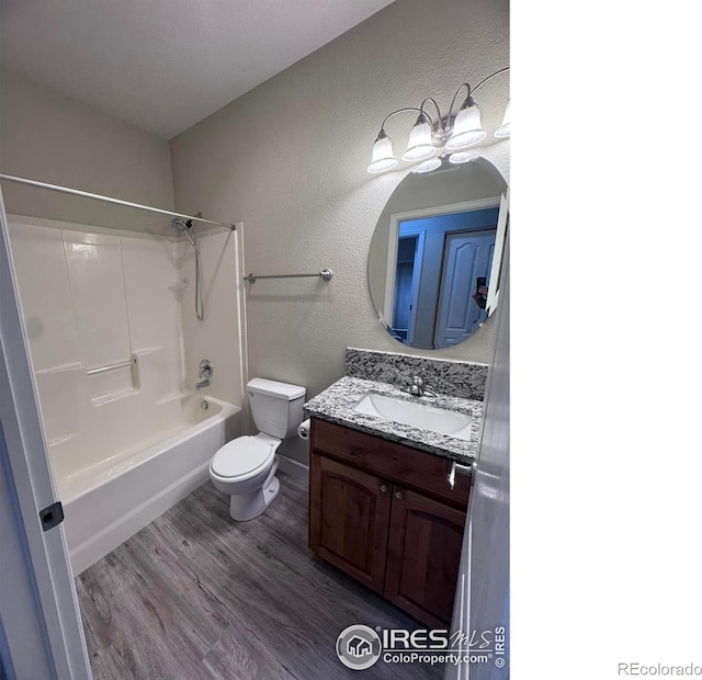 full bathroom with hardwood / wood-style floors, vanity, shower / bath combination, and toilet