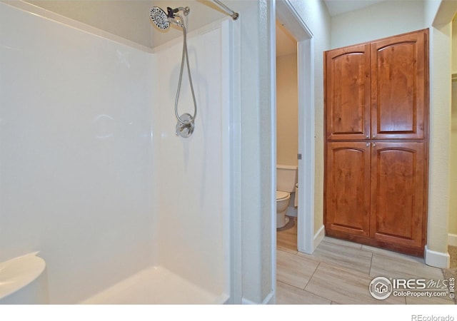 bathroom featuring toilet and walk in shower