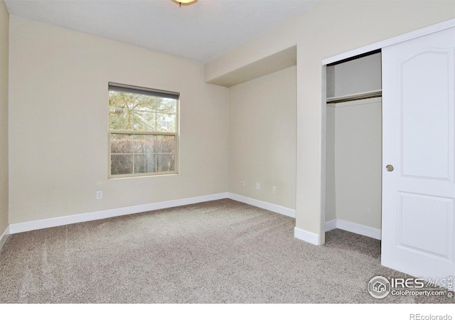 unfurnished bedroom featuring light carpet and a closet