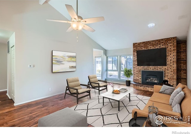 living room featuring hardwood / wood-style flooring, ceiling fan, a fireplace, and high vaulted ceiling