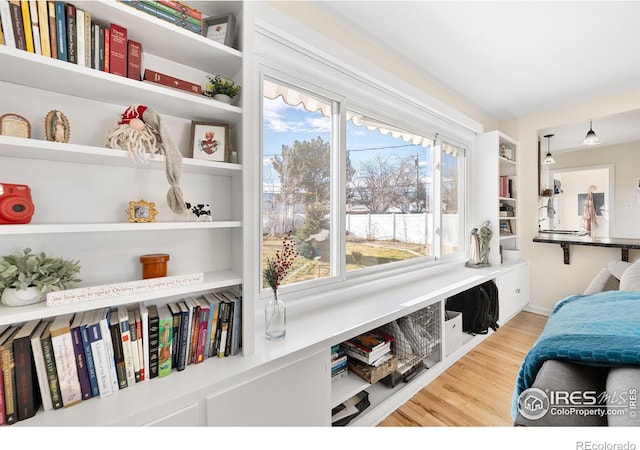 sitting room with built in features and wood-type flooring