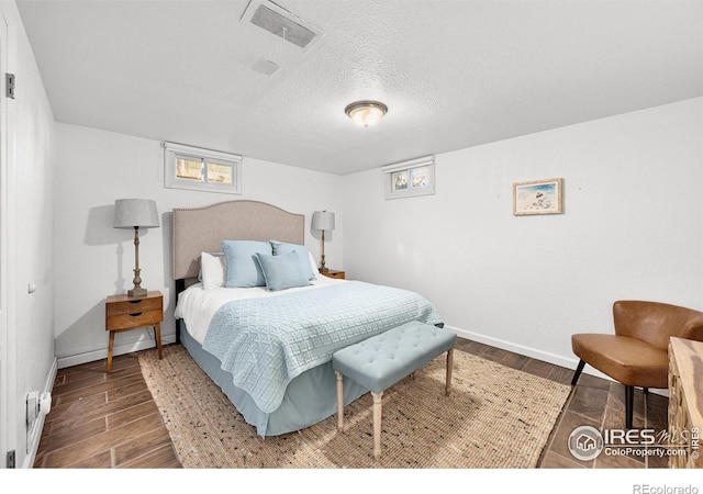 bedroom featuring a textured ceiling and dark hardwood / wood-style floors