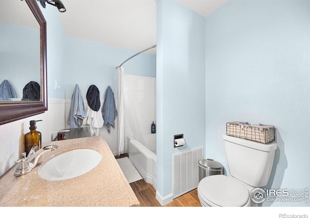 full bathroom featuring radiator, sink, wood-type flooring, toilet, and shower / tub combo with curtain