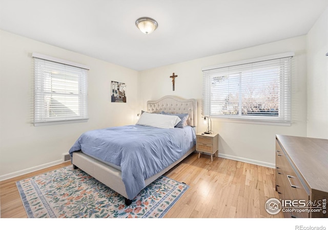 bedroom with light wood-type flooring and multiple windows