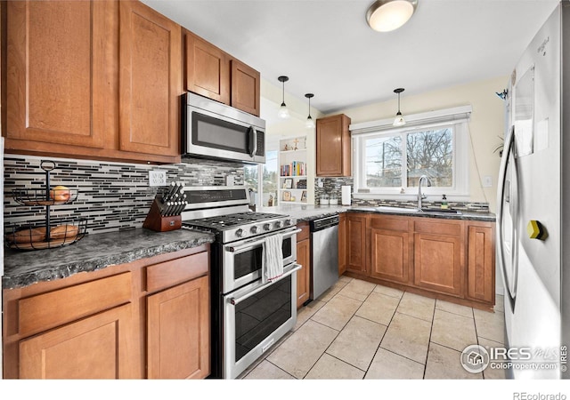 kitchen with sink, hanging light fixtures, decorative backsplash, light tile patterned floors, and appliances with stainless steel finishes