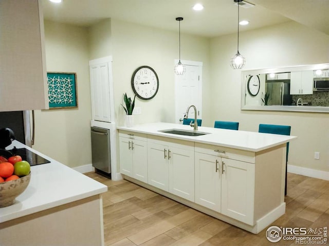 kitchen with white cabinets, pendant lighting, stainless steel appliances, and sink