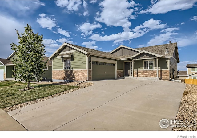 craftsman inspired home featuring a garage and a front lawn