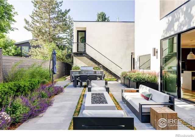 view of patio / terrace with grilling area and an outdoor living space with a fire pit