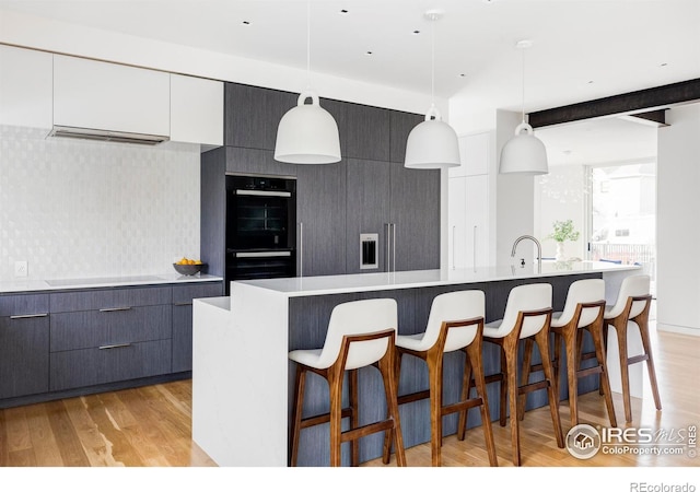 kitchen with white cabinetry, a large island, and hanging light fixtures