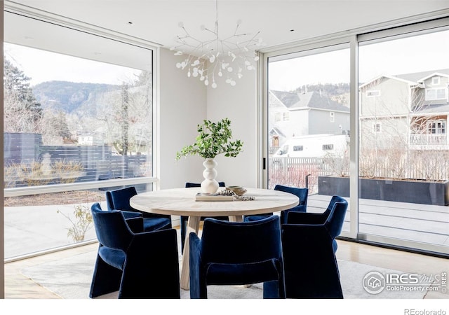 dining room with hardwood / wood-style flooring, plenty of natural light, floor to ceiling windows, and a chandelier