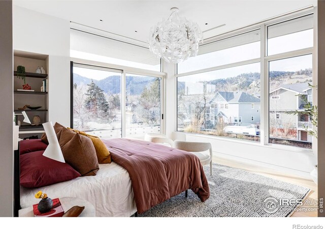 bedroom with hardwood / wood-style floors and an inviting chandelier