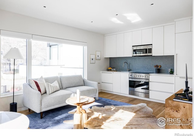 living room with sink and light wood-type flooring