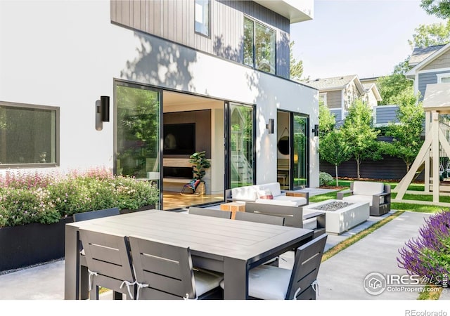 back of house featuring a patio area and an outdoor living space with a fire pit