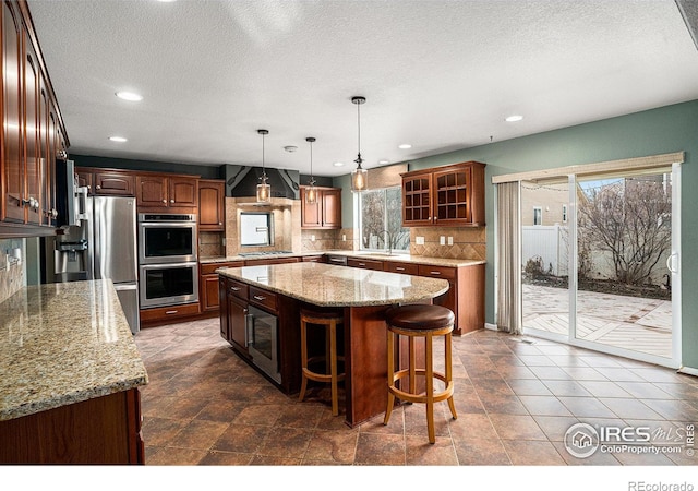 kitchen with backsplash, a kitchen island, a healthy amount of sunlight, and stainless steel appliances