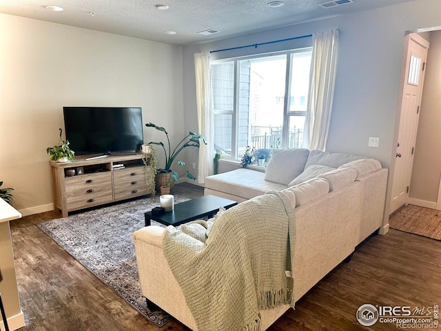 living room featuring a textured ceiling and dark hardwood / wood-style flooring