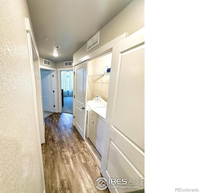 hall with hardwood / wood-style flooring and washing machine and clothes dryer