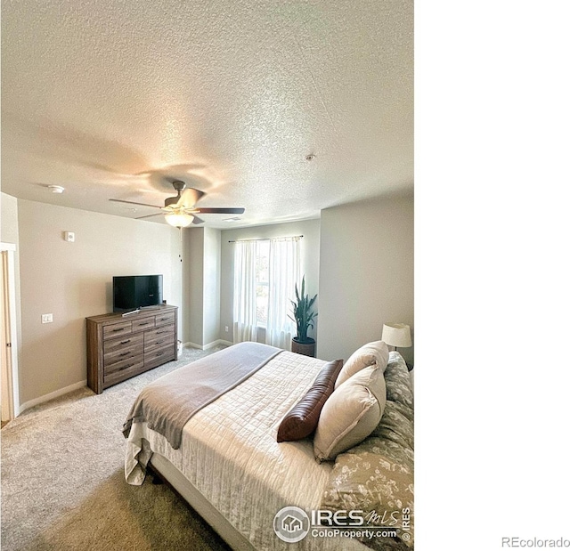 carpeted bedroom with a textured ceiling and ceiling fan