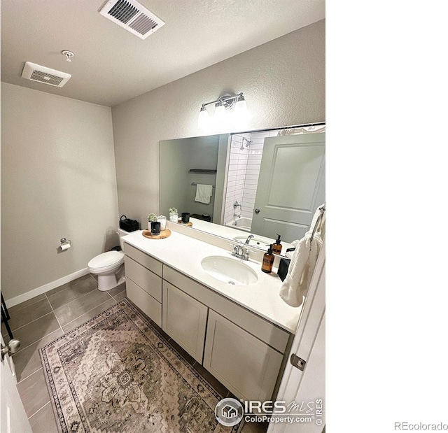 full bathroom featuring tile patterned floors, a textured ceiling, toilet, shower / tub combination, and vanity