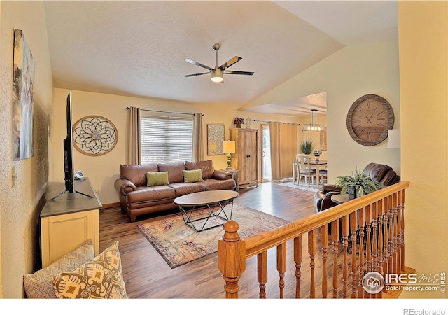 living room with hardwood / wood-style floors, ceiling fan, lofted ceiling, and a textured ceiling