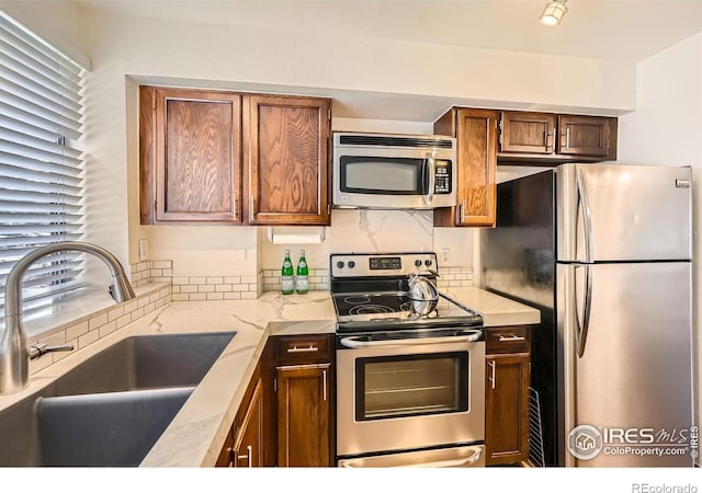 kitchen with decorative backsplash, sink, and stainless steel appliances