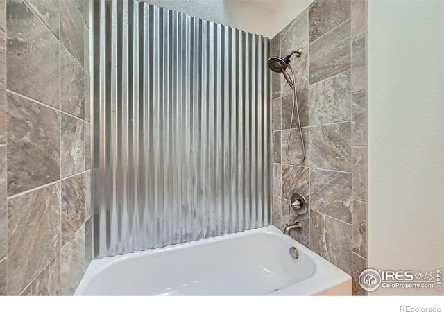 bathroom featuring tiled shower / bath