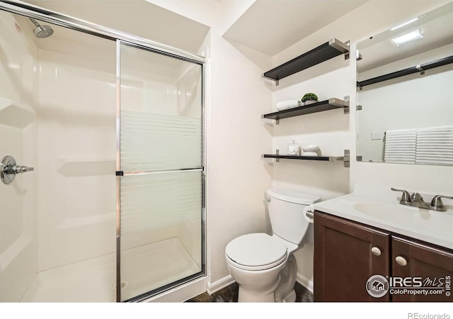 bathroom with vanity, toilet, and a shower with door