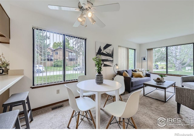 carpeted dining area featuring ceiling fan