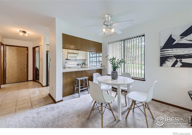 dining space with light colored carpet and ceiling fan