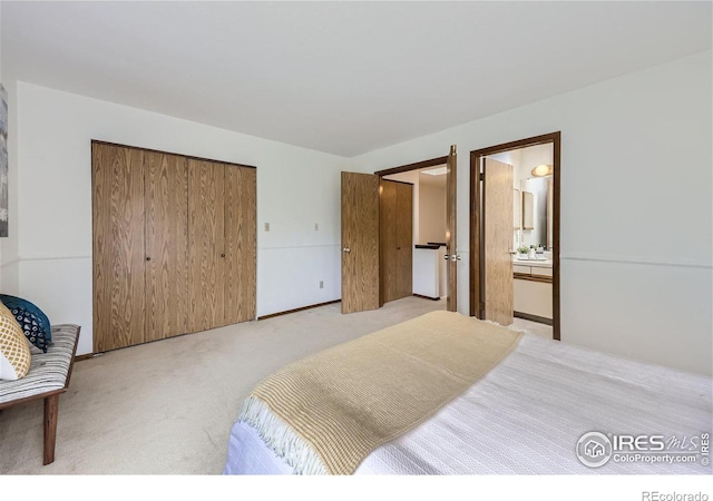 bedroom featuring light carpet and connected bathroom