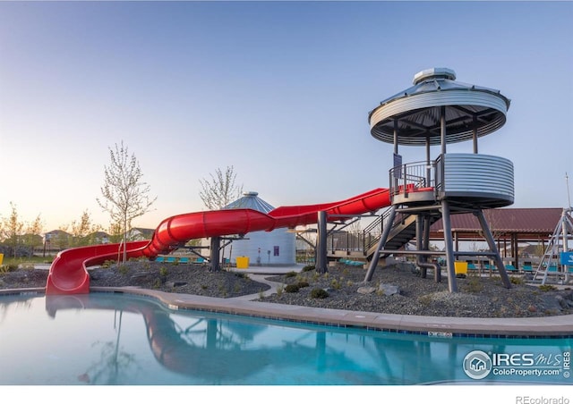 pool at dusk with a water slide