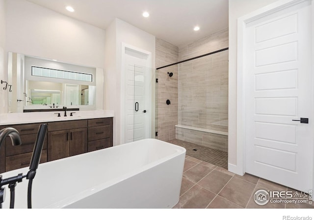 bathroom featuring tile patterned flooring, vanity, and shower with separate bathtub