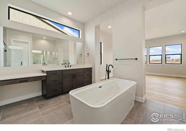 bathroom featuring a bathtub, vanity, and tile patterned flooring