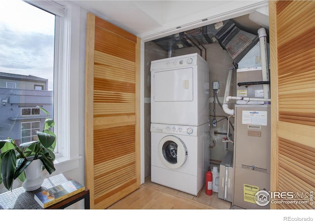 clothes washing area with stacked washer and clothes dryer