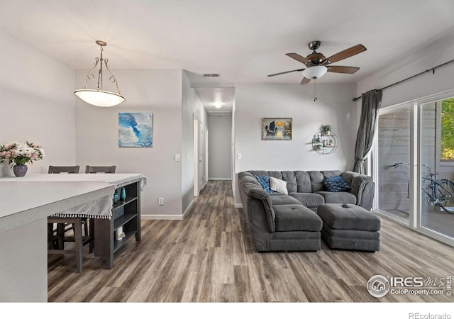 living room featuring wood-type flooring and ceiling fan