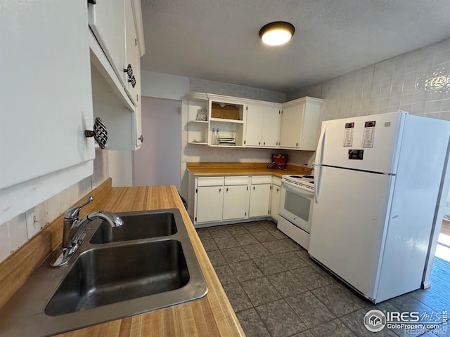 kitchen featuring a textured ceiling, white appliances, a sink, white cabinets, and open shelves