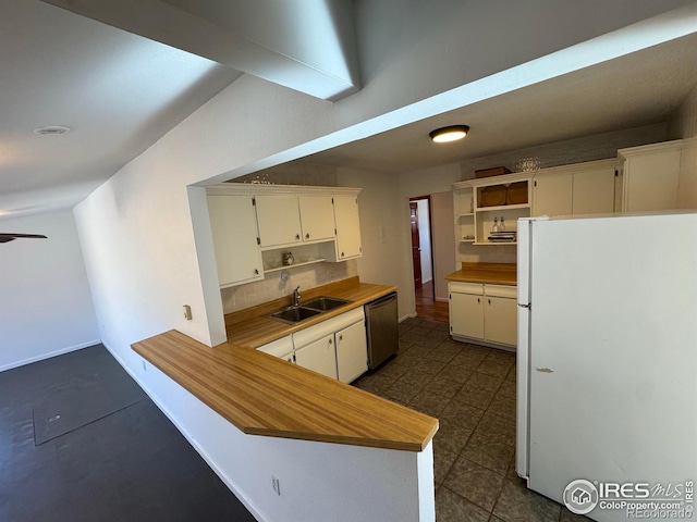 kitchen with open shelves, backsplash, freestanding refrigerator, a sink, and dishwasher