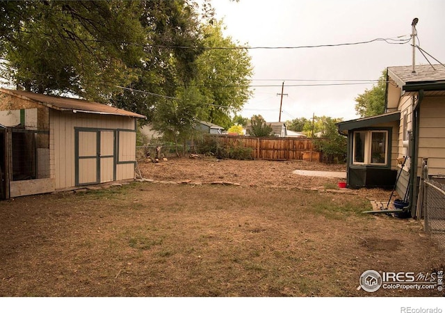 view of yard featuring an outbuilding, a storage shed, and a fenced backyard