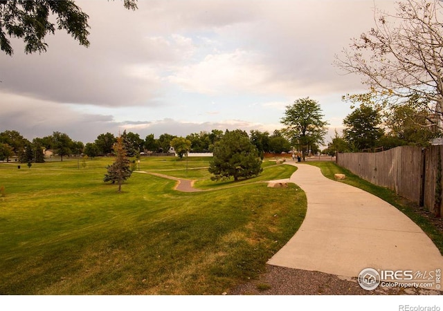 view of community with fence and a lawn