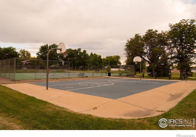 view of sport court with a tennis court, community basketball court, and fence