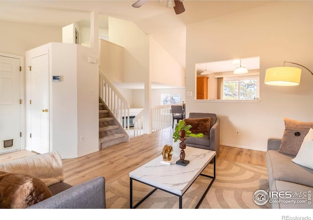 living room featuring ceiling fan, light hardwood / wood-style flooring, and high vaulted ceiling