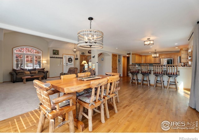 dining space with a chandelier and light hardwood / wood-style floors