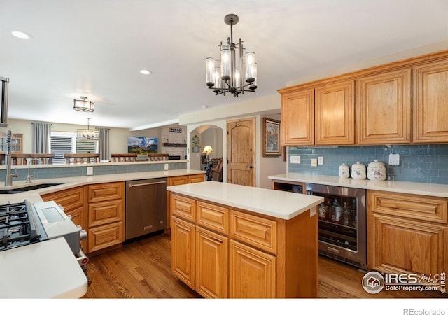 kitchen with dishwasher, sink, wine cooler, decorative backsplash, and a notable chandelier