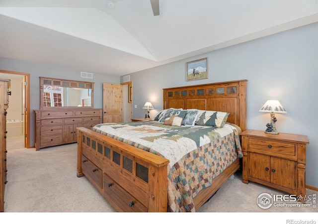 bedroom featuring light carpet, ensuite bathroom, ceiling fan, and lofted ceiling