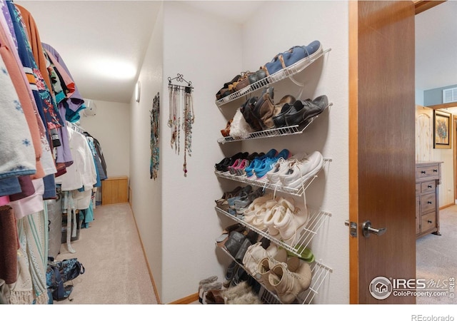 walk in closet featuring light carpet