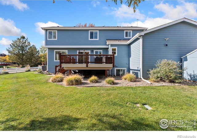 rear view of property featuring a lawn and a wooden deck