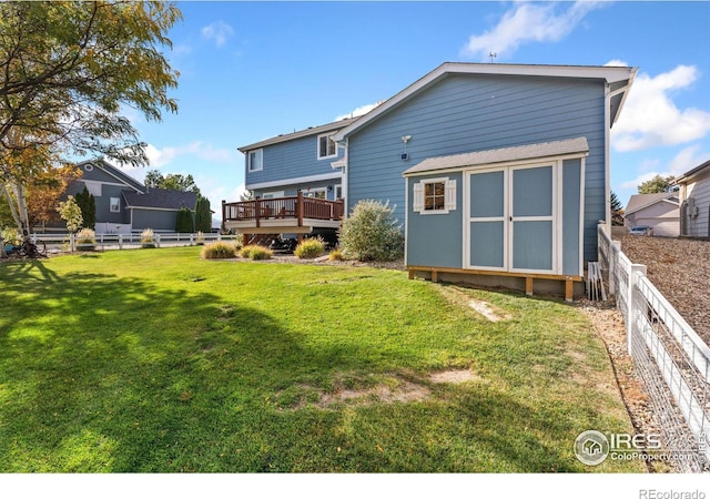 back of house featuring a storage unit, a wooden deck, and a lawn