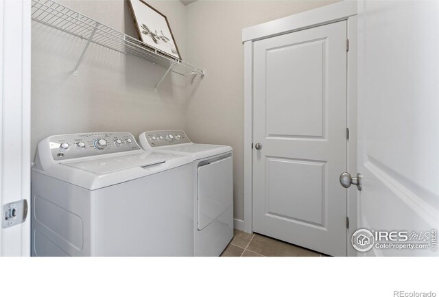 laundry area with light tile patterned floors and washing machine and dryer