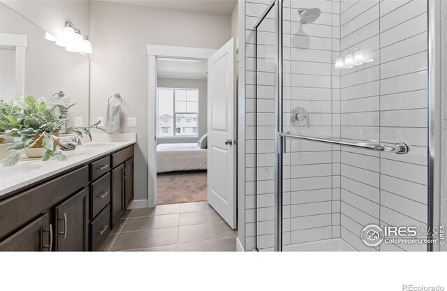 bathroom with walk in shower, vanity, and tile patterned flooring