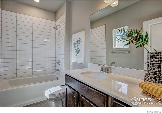 full bathroom with vanity, toilet, and tiled shower / bath