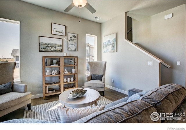 living room with ceiling fan and dark wood-type flooring